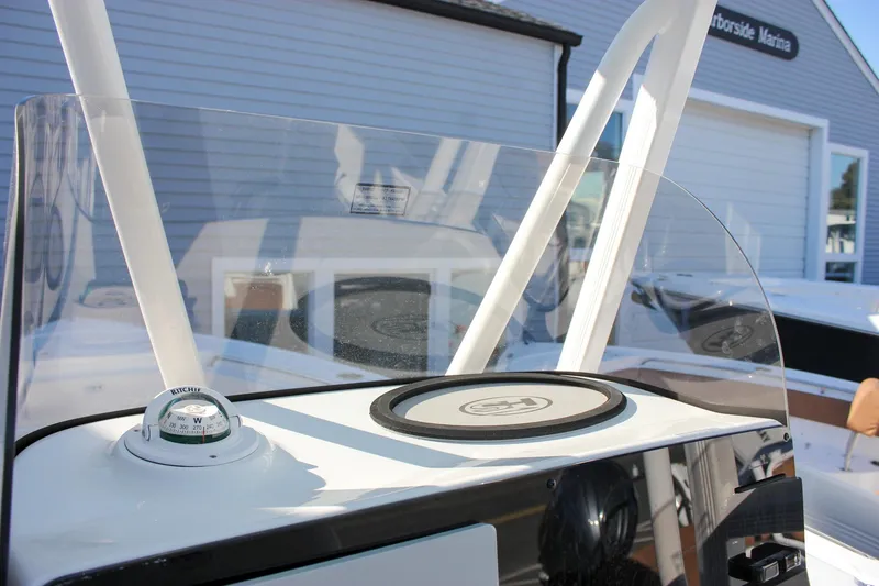 Slide: The Image of 2026 Sea Hunt Ultra 229 boat dashboard with compass and windshield at marina. - 38