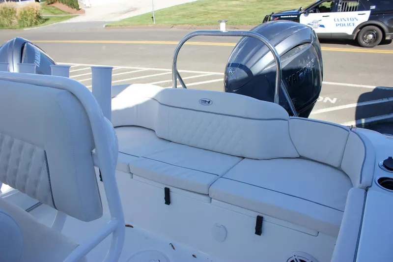 Slide: The Image of 2026 Sea Hunt Ultra 229 boat interior with Yamaha engine, parked near a police vehicle. - 48