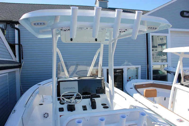 Slide: The Image of 2026 Sea Hunt Ultra 229 boat with Garmin navigation, docked near a blue building. - 52
