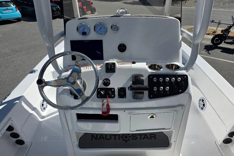 Slide: The Image of 2026 NauticStar 224 Bay boat console with steering wheel, gauges, and controls. - 16
