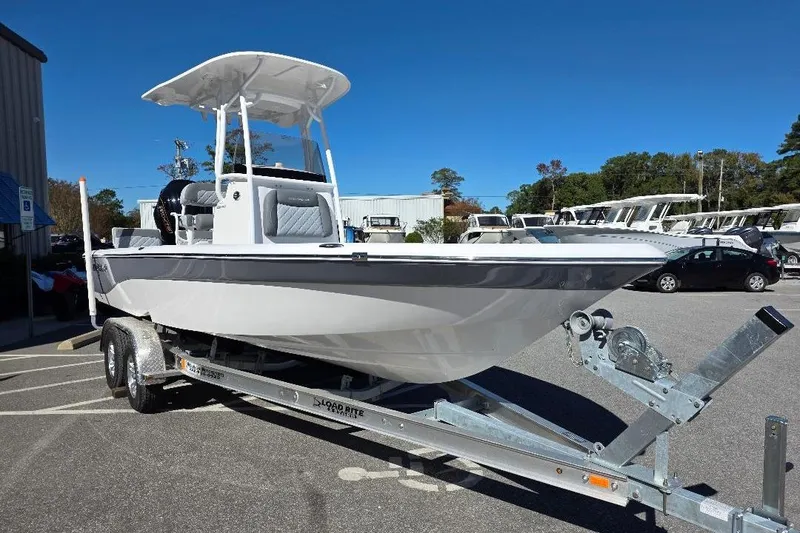 Slide: The Image of 2026 NauticStar 224 Bay boat on trailer, parked outdoors under clear blue sky. - 3