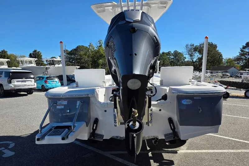 Slide: The Image of 2026 NauticStar 224 Bay boat with outboard motor, parked in a marina. - 6