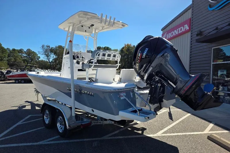 Slide: The Image of 2026 NauticStar 224 Bay boat with Yamaha outboard motor on trailer, parked outside dealership. - 7