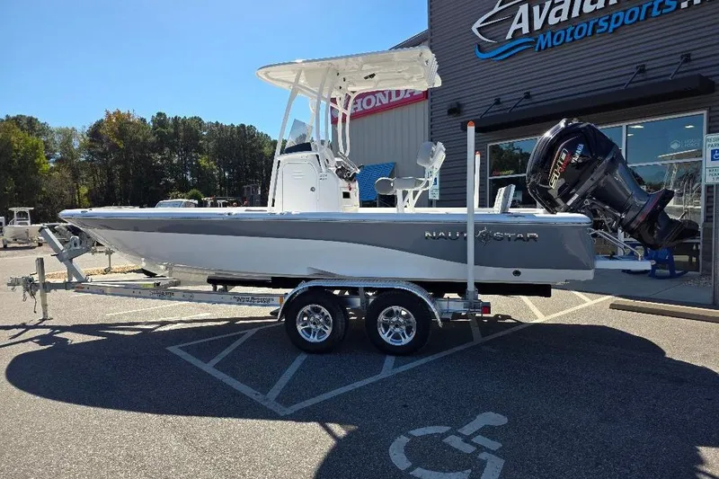 Slide: The Image of 2026 NauticStar 224 Bay boat on trailer outside dealership. - 8