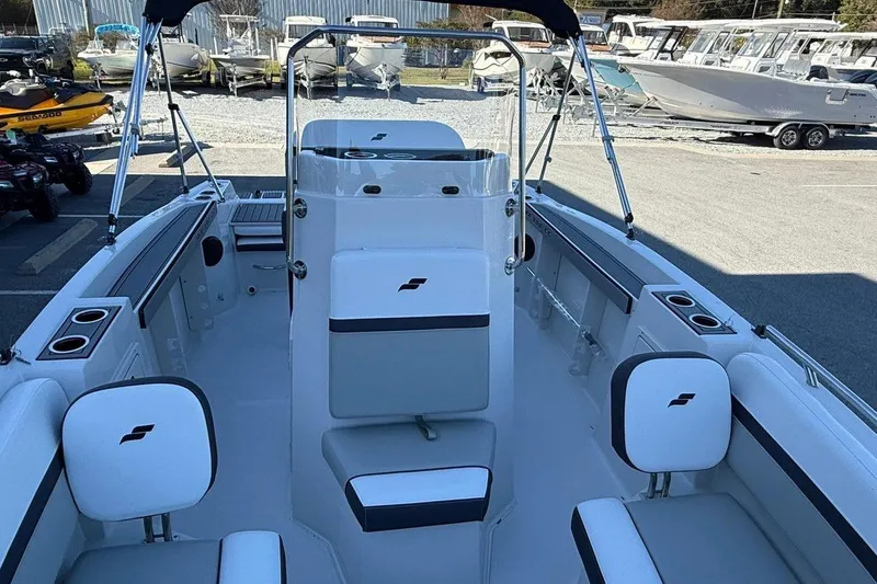 Slide: The Image of 2026 Starcraft SVX 191 OB boat interior with seating and console, displayed outdoors. - 10