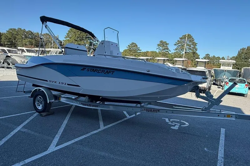 Slide: The Image of 2026 Starcraft SVX 191 OB boat on trailer in parking lot, clear sky background. - 4