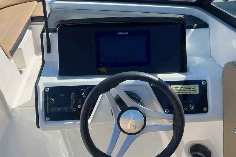 Slide: The Image of 2023 Sea Ray SPX 230 Outboard dashboard with steering wheel and control panel. - 11