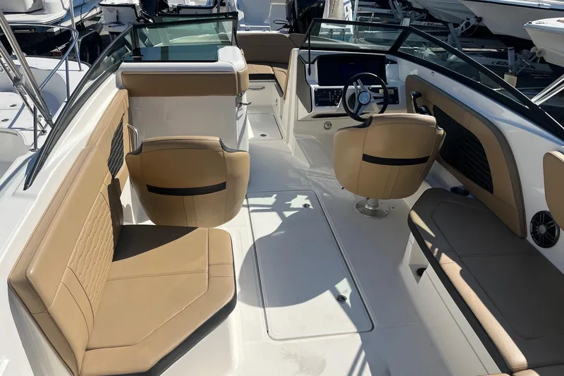 Slide: The Image of 2023 Sea Ray SPX 230 Outboard interior with tan seating and modern dashboard. - 12