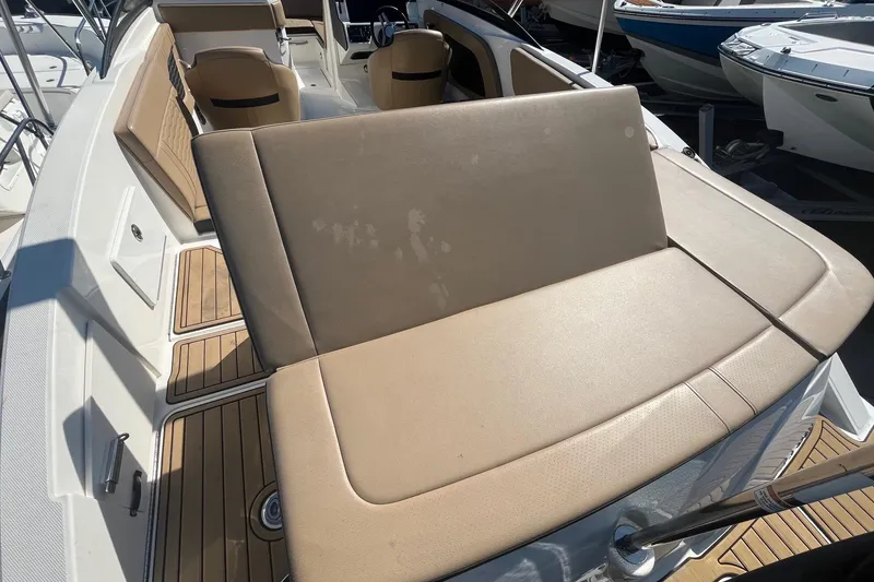 Slide: The Image of 2023 Sea Ray SPX 230 Outboard boat interior with tan seating and wood accents. - 4