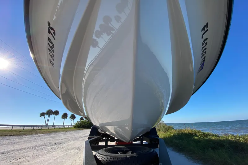 Slide: The Image of 2024 Drake Boatworks Nomad on trailer by the coast, under clear blue sky. - 10
