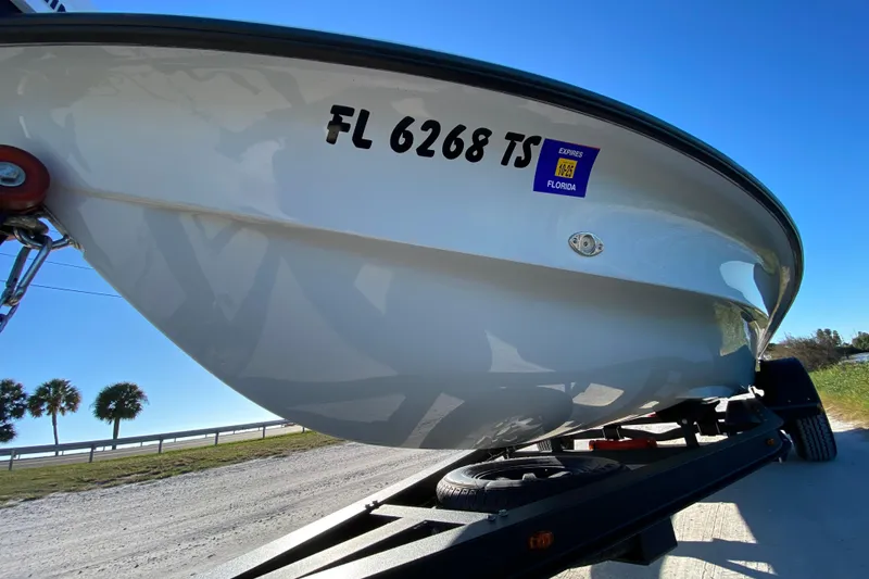 Slide: The Image of 2024 Drake Boatworks Nomad on trailer, Florida registration visible, sunny day backdrop. - 15