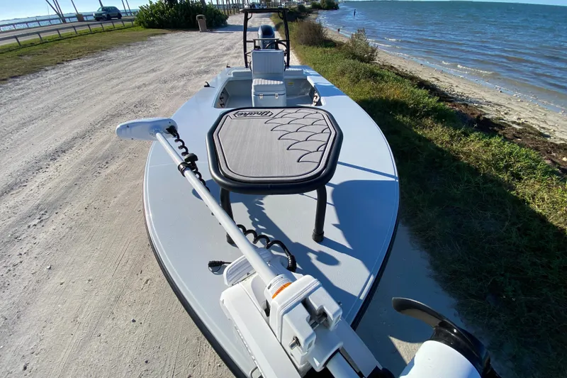 Slide: The Image of 2024 Drake Boatworks Nomad skiff on a sandy shore by the ocean. - 17