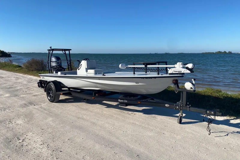 Slide: The Image of 2024 Drake Boatworks Nomad on trailer by the ocean, ready for adventure. - 2