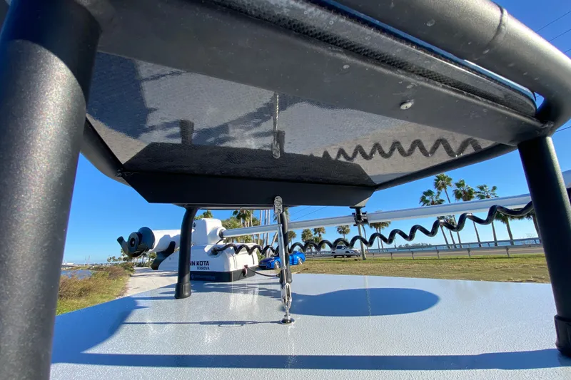 Slide: The Image of 2024 Drake Boatworks Nomad with trolling motor, viewed from below, against a sunny backdrop. - 26