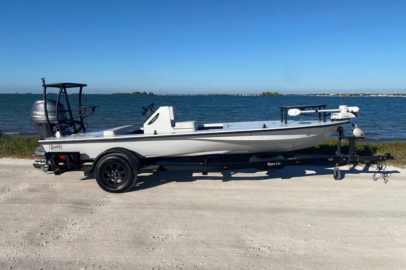 Slide: The Image of 2024 Drake Boatworks Nomad on trailer by the sea, showcasing sleek design. - 3