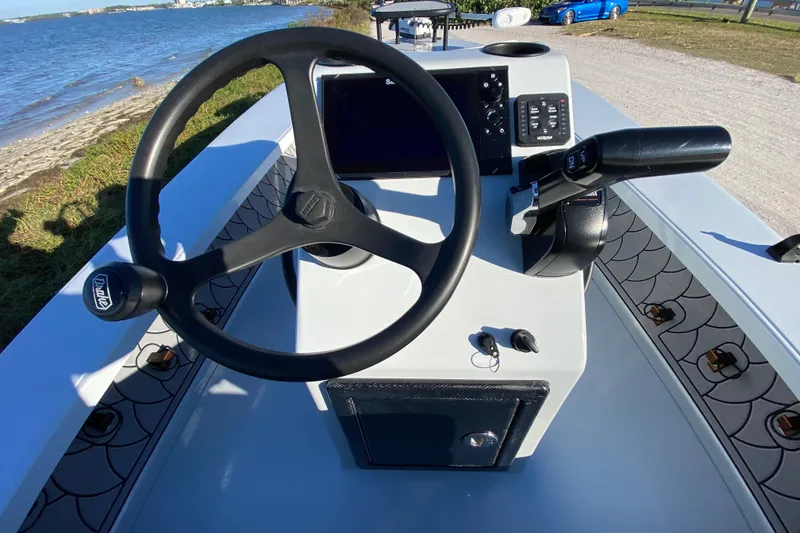 Slide: The Image of 2024 Drake Boatworks Nomad steering console with modern controls by the water. - 38
