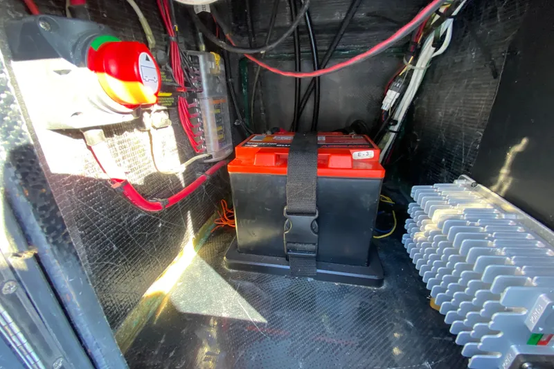 Slide: The Image of 2024 Drake Boatworks Nomad electrical compartment with battery and wiring setup. - 43