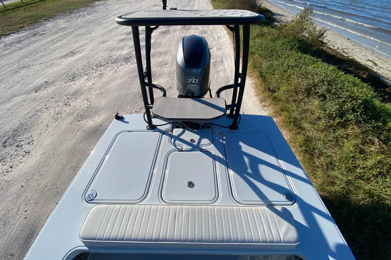 Slide: The Image of 2024 Drake Boatworks Nomad on sandy shore, showcasing sleek design and powerful engine. - 45