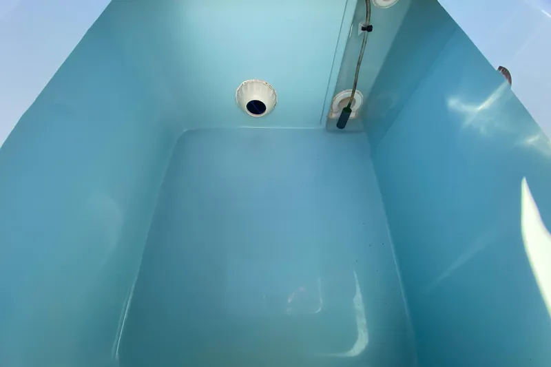 Slide: The Image of 2024 Drake Boatworks Nomad interior compartment with blue finish and drainage system. - 55