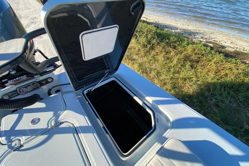 Slide: The Image of 2024 Drake Boatworks Nomad storage compartment open by the water. - 57