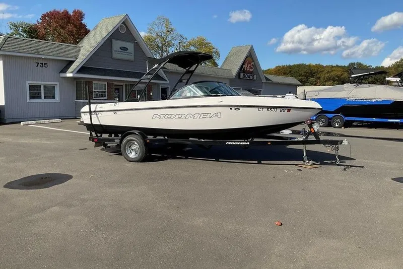Slide: The Image of 2015 Moomba Outback V boat on trailer at dealership, sunny day. - 8