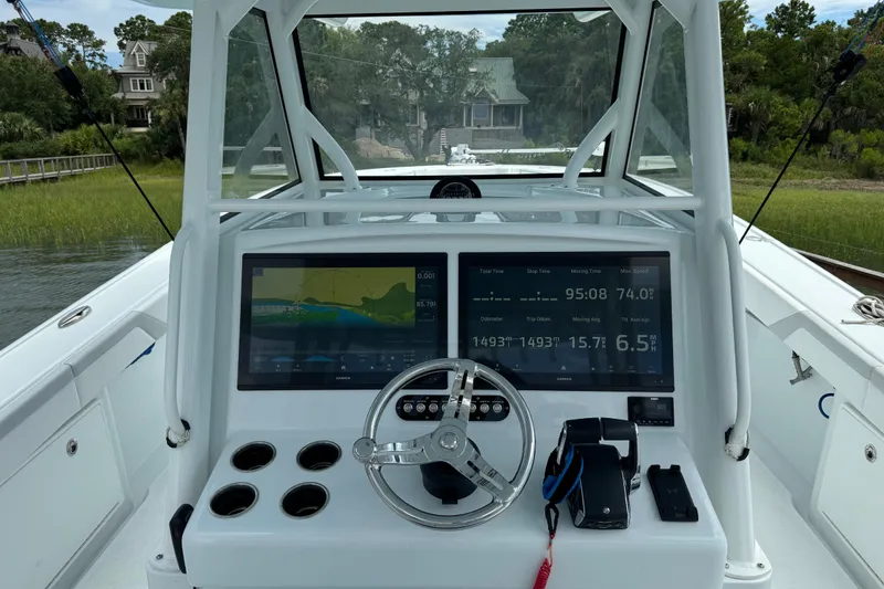 Slide: The Image of 2024 Yellowfin 39 Offshore boat dashboard with navigation screens and steering wheel. - 18