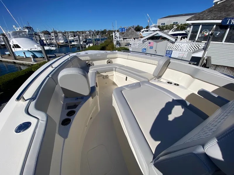 Slide: The Image of 2026 Scout 260 LXF boat interior at marina, showcasing seating and cup holders. - 11