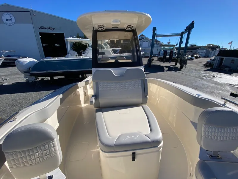 Slide: The Image of 2026 Scout 260 LXF boat interior with cushioned seating at a marina. - 12
