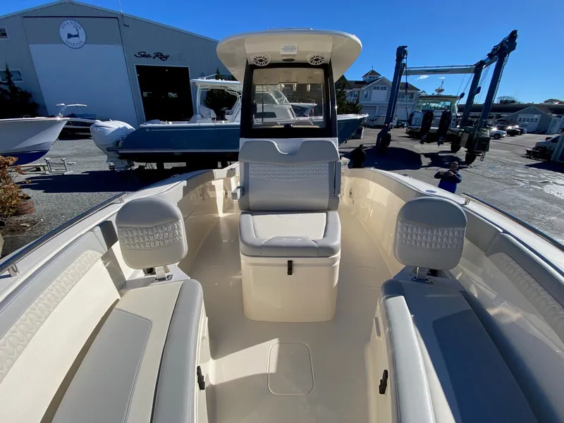 Slide: The Image of 2026 Scout 260 LXF boat interior with seating, docked at a marina. - 13