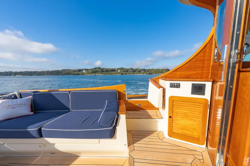 Slide: The Image of Hinckley Talaria 48 Flybridge 2013 yacht deck with blue seating and scenic water view. - 15