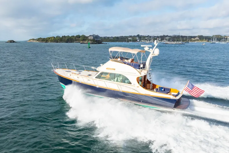 Slide: The Image of 2013 Hinckley Talaria 48 Flybridge yacht cruising on open water with American flag. - 2
