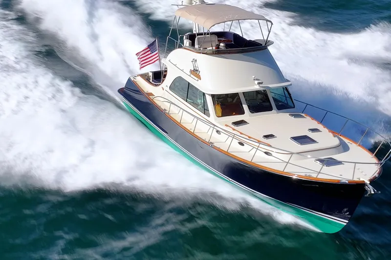 Slide: The Image of 2013 Hinckley Talaria 48 Flybridge yacht cruising on open water, American flag displayed. - 3