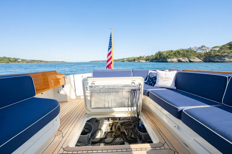 Slide: The Image of Hinckley Talaria 48 Flybridge 2013 yacht deck with blue seating and open engine hatch. - 34