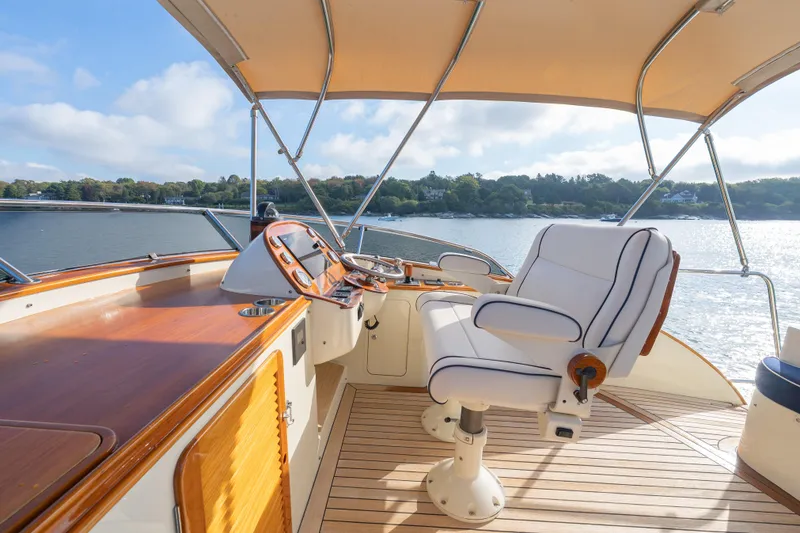 Slide: The Image of 2013 Hinckley Talaria 48 Flybridge helm with luxurious seating and scenic water view. - 6