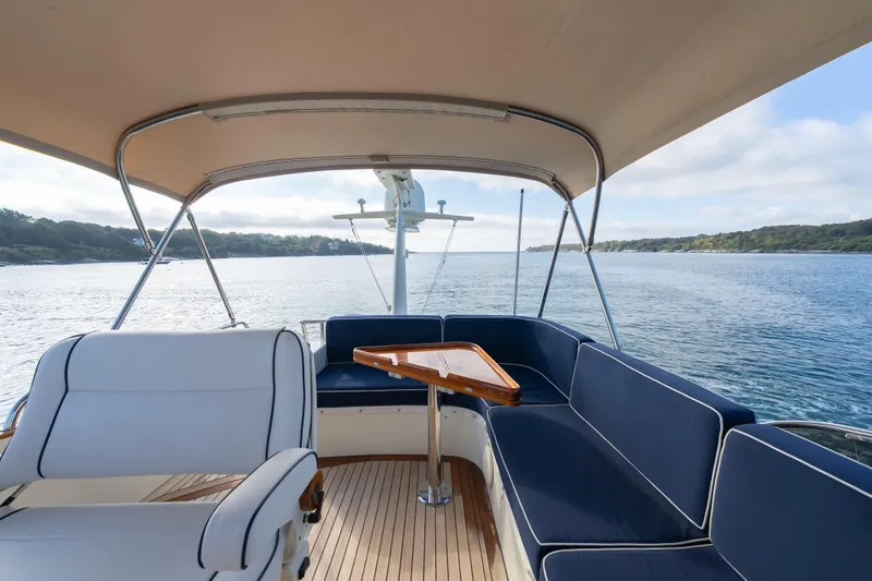 Slide: The Image of 2013 Hinckley Talaria 48 Flybridge with elegant seating and scenic water view. - 8