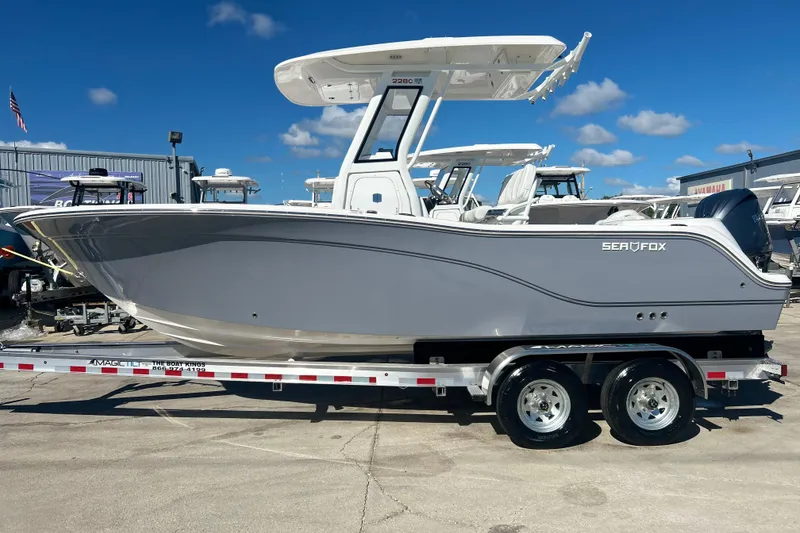Slide: The Image of 2026 Sea Fox 228 Commander boat on trailer, displayed outdoors under clear blue sky. - 1