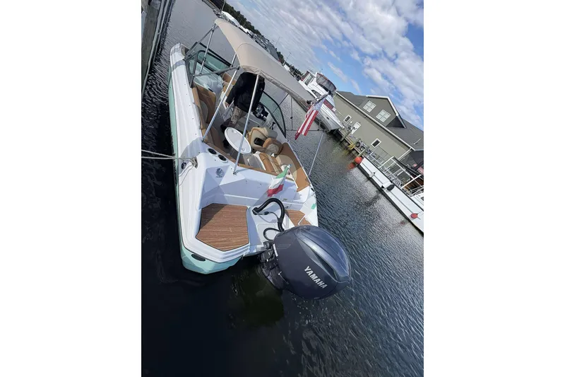 Slide: The Image of 2024 NauticStar 223 DC boat docked, featuring Yamaha outboard motor, under a partly cloudy sky. - 22
