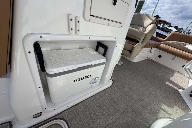 Slide: The Image of 2024 NauticStar 223 DC boat interior with Igloo cooler and comfortable seating. - 23