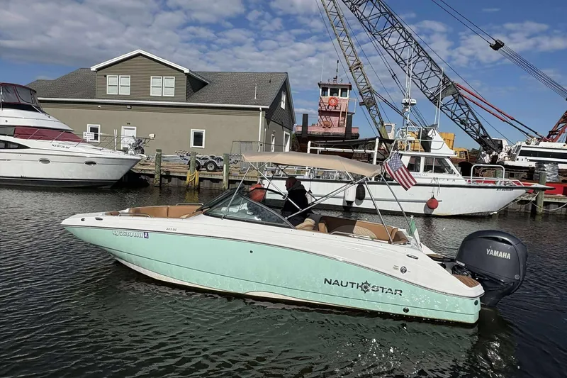 Slide: The Image of 2024 NauticStar 223 DC boat with Yamaha engine on water near dock. - 3