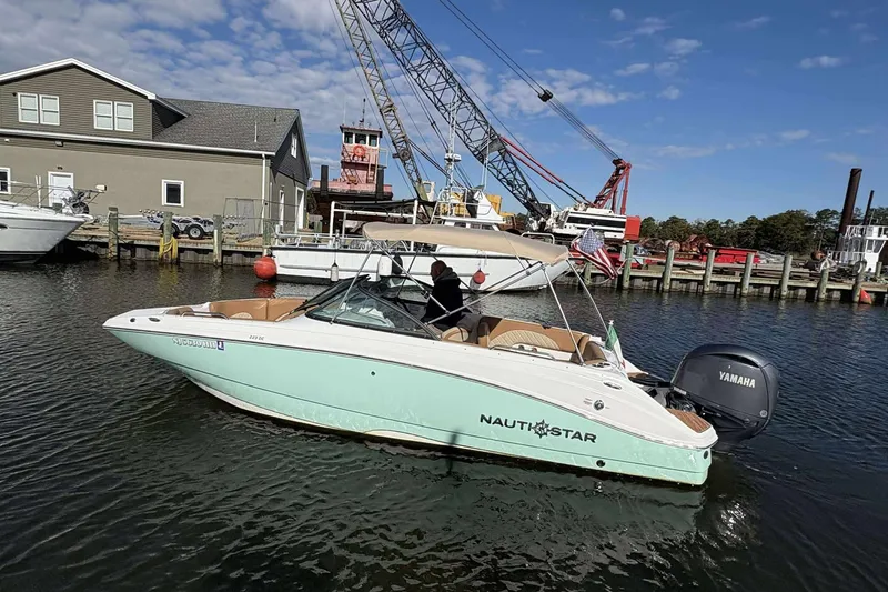 Slide: The Image of 2024 NauticStar 223 DC boat docked, featuring Yamaha engine, under clear blue sky. - 4
