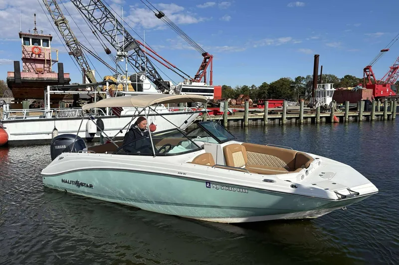 Slide: The Image of 2024 NauticStar 223 DC boat in marina, featuring sleek design and Yamaha engine. - 5