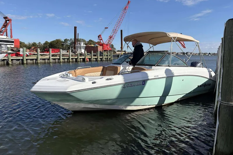 Slide: The Image of 2024 NauticStar 223 DC boat docked, featuring a sleek design and spacious seating. - 6