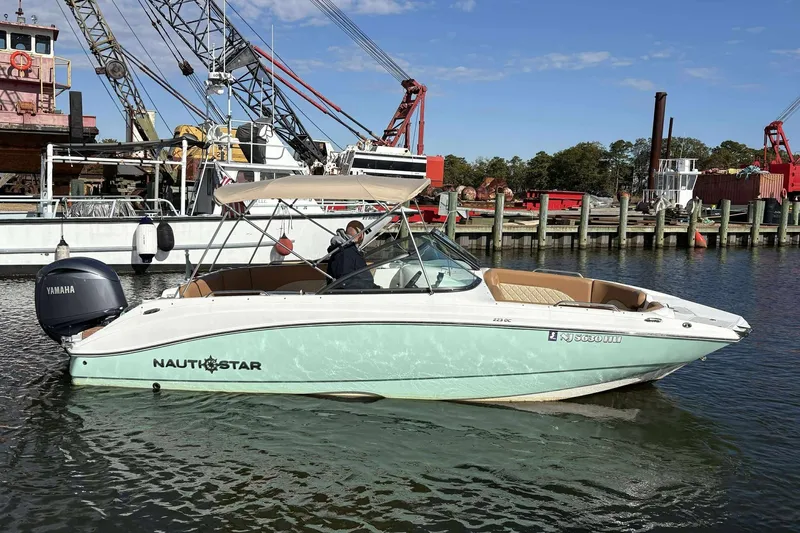 Slide: The Image of 2024 NauticStar 223 DC boat with Yamaha engine docked in marina. - 7
