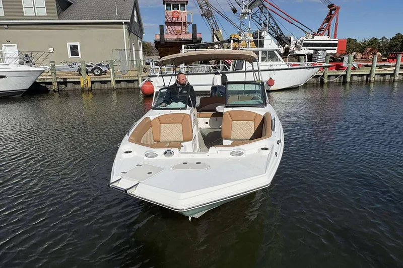 Slide: The Image of 2024 NauticStar 223 DC boat docked in marina, featuring tan seating and sleek design. - 8