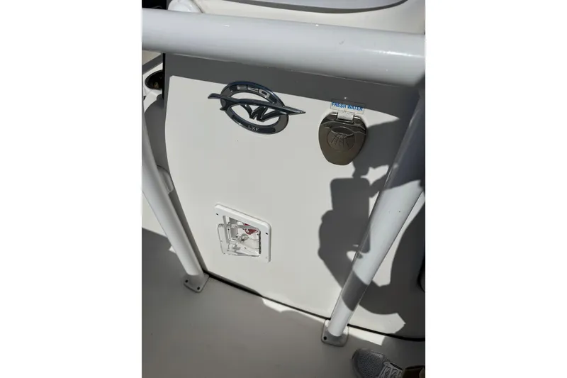Slide: The Image of 2021 Tidewater 220 LXF boat detail with fresh water access and logo. - 11
