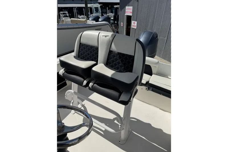 Slide: The Image of 2021 Tidewater 220 LXF boat seats, dual helm chairs with black and gray upholstery. - 14