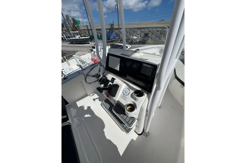 Slide: The Image of 2021 Tidewater 220 LXF boat console with steering wheel and controls under blue sky. - 17