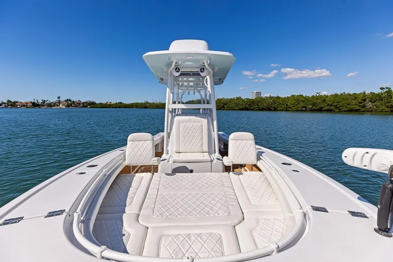 Slide: The Image of 2021 Barker Boatworks 26 Open on calm water, featuring luxurious seating and clear blue skies. - 17