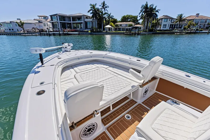 Slide: The Image of 2021 Barker Boatworks 26 Open on water, luxurious seating, waterfront homes in background. - 23