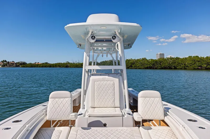 Slide: The Image of 2021 Barker Boatworks 26 Open on calm water, featuring luxurious seating and clear blue sky. - 24